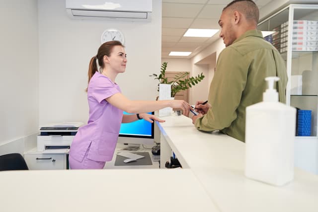 Receptionist talking with client at front desk